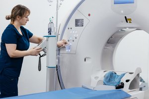 Photograph of a nurse in a hospital operating a CT-scanner