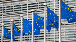 Photograph of row of six European Union flags flying from poles lined in front of the Berlaymont building, Brussels, Belgium