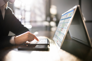 Close-up of a man analyzing a digital e-invoice on a tablet, using a separate keyboard