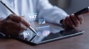 Close-up of the hands of a finance professional using a tablet and a smartphone