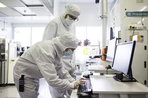 Operators checking the silicon wafer deposit parameters in the CEA-Leti clean room.