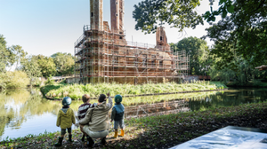 Father showing to his three young children an old building with scaffolding