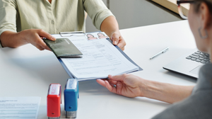 High angle view shot of unrecognizable woman applying for travel visa giving passport