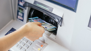 Close up of a woman's hand withdrawing cash, euro bills from the ATM bank machine