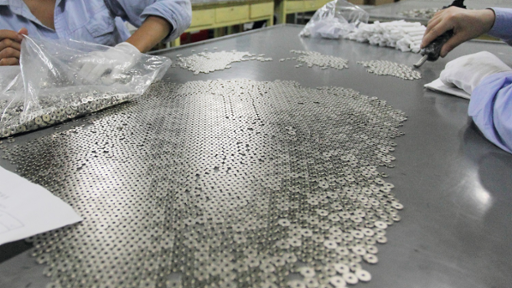 Workers manufacturing industrial magnet parts