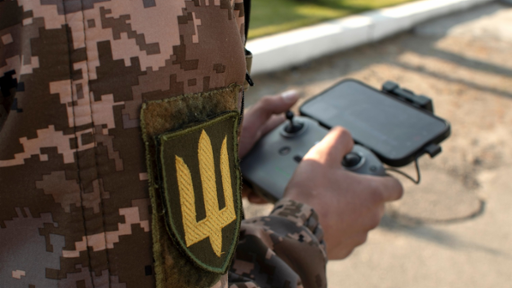 Photograph of Ukrainian military personnel holding a drone control device.