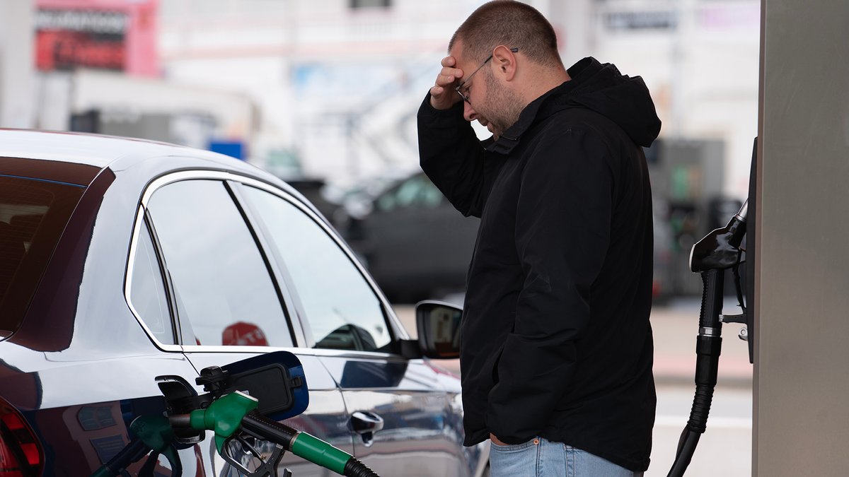 Man looking frustrated while refueling his car