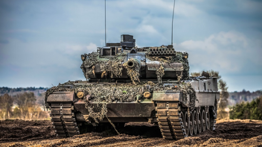 Photograph of a military tank in a sandy landscape.