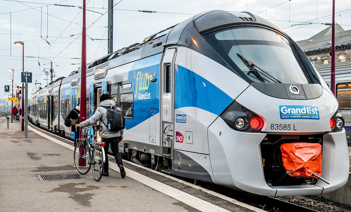 Photo of a modern train waiting at an outdoor station for passengers to board.