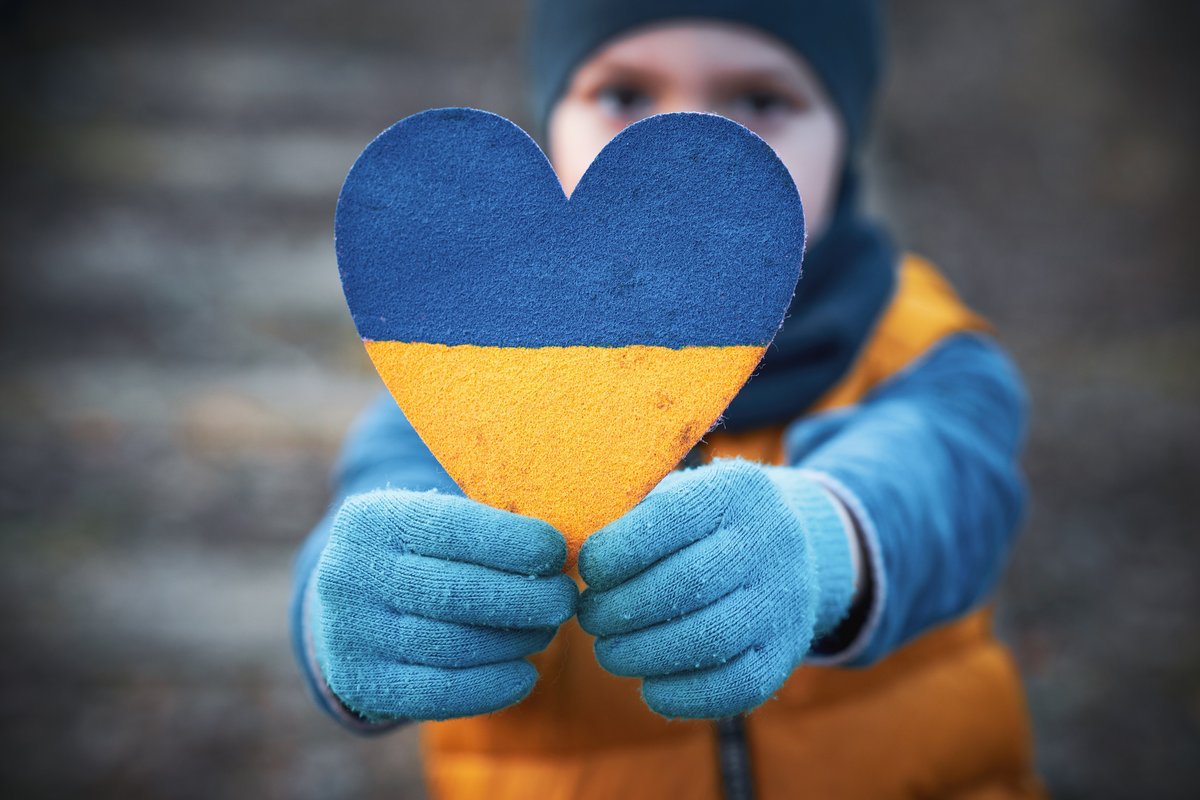 Picture of a child holding a heart in the colours of the Ukrainian flag