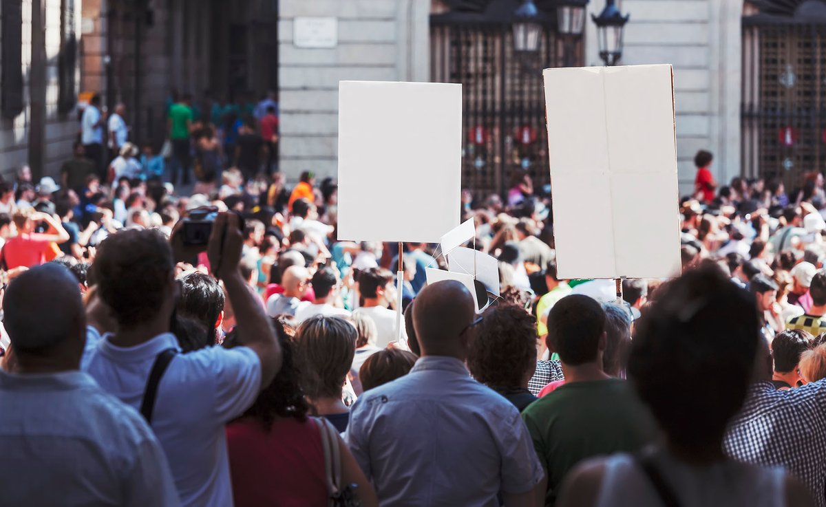 Picture showing a large crowd demonstrating in the street with placards.