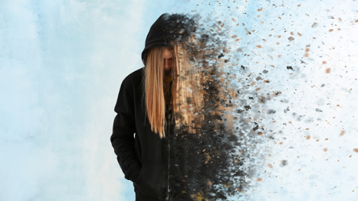 Photograph of depressed looking teenage girl in a black hoody in front of a cloudy background