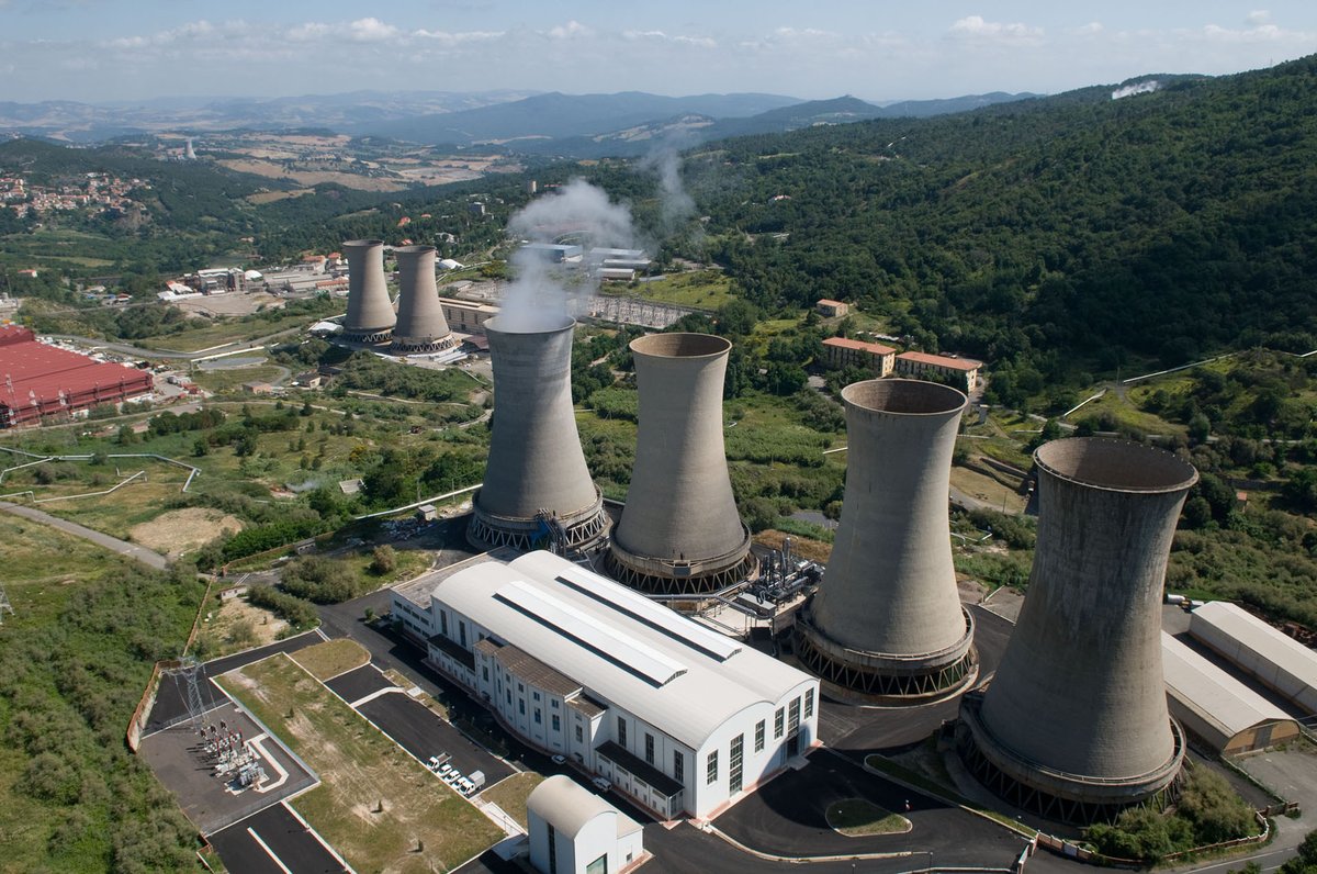 Photograph of a geothermal powerplant in a wooded valley