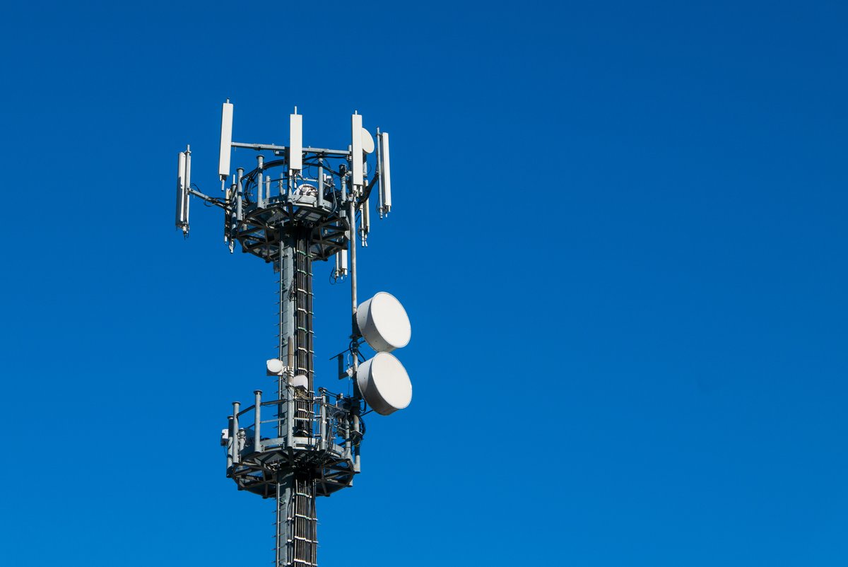 Photograph of a telecommunications tower set against a blue sky.