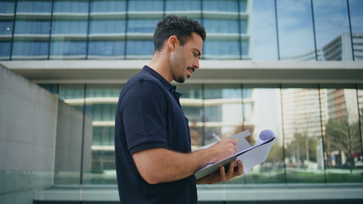 Photo of a worker reviewing documents outdoors